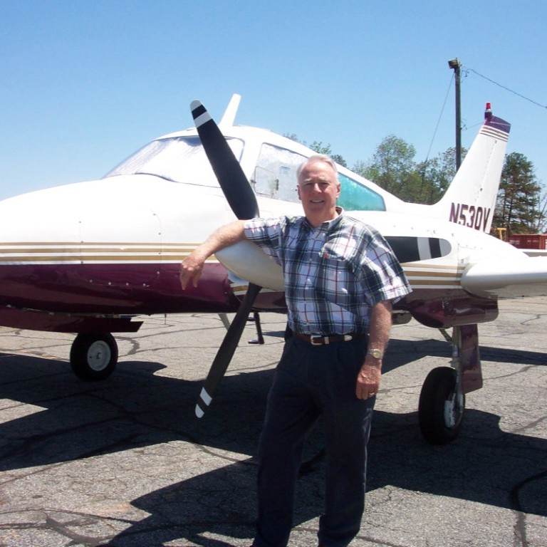 Don Stevens in front of an airplane on a runway